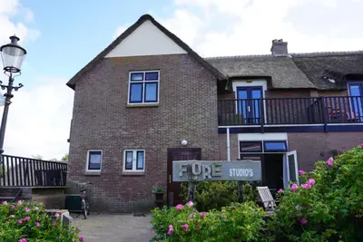 a brick house with a sign that says true stops at villa Flore, studio's in Bergen aan Zee