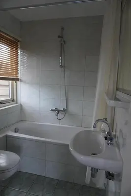a bathroom with a tub and a sink and a toilet at villa Flore, studio's in Bergen aan Zee