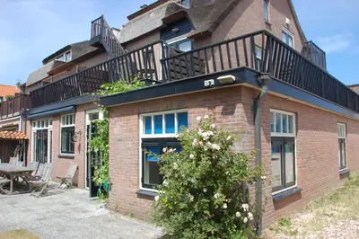 a brick building with a balcony on top of it at villa Flore, studio's in Bergen aan Zee