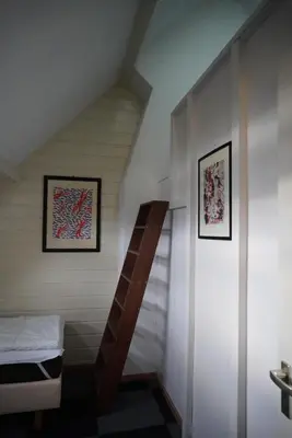 a attic room with a ladder and a bed at villa Flore, studio's in Bergen aan Zee