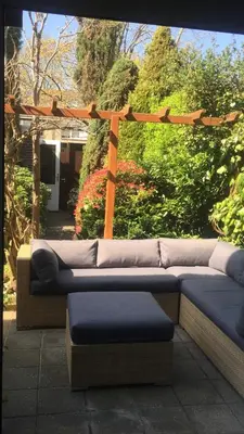 a couch sitting on a patio with a pergola at Cozy room in residential Alkmaar - Free parking in Alkmaar