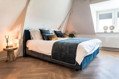 a bedroom with a large bed with pillows at de Vogelensangh in Vogelenzang