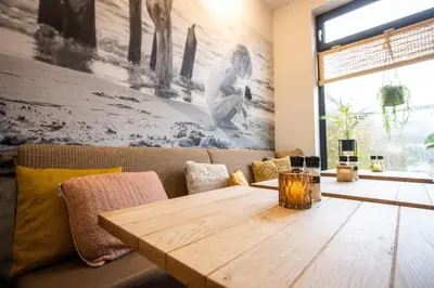 a wooden table sitting on a couch in a room at Hotel Neptunus in Egmond aan Zee