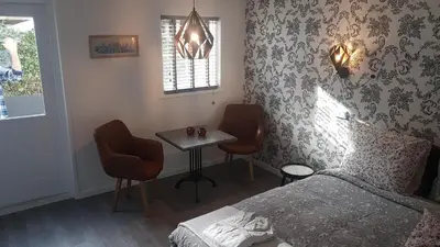 a bedroom with a bed and a table and chairs at B&B de Valkenhorst in Lelystad