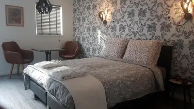 a bedroom with a bed and a table and chairs at B&B de Valkenhorst in Lelystad