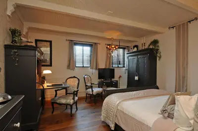 a bedroom with a bed and a desk with a computer at B&B de Valkenhorst in Lelystad