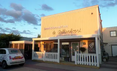 a white car parked in front of a building at B&B de Valkenhorst in Lelystad
