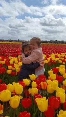 two children hugging in a field of tulips at Pension Corper in Zandvoort