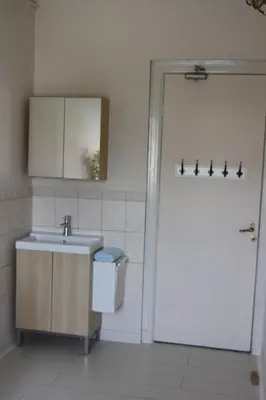 a bathroom with a sink and a toilet and a door at Pension Corper in Zandvoort
