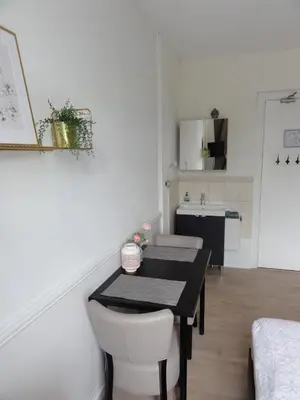 a dining room with a table and a kitchen at Pension Corper in Zandvoort
