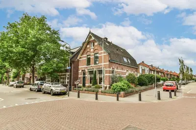 a large brick building on a street with cars parked at B&B De Duinhoek in Beverwijk