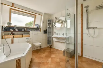 a bathroom with a tub and a sink and a shower at B&B De Duinhoek in Beverwijk