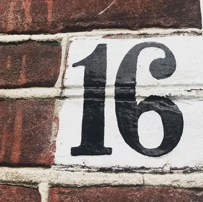 a sign on the side of a brick wall at De Pelgrimsplaats in Leiden