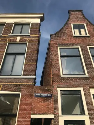 a tall brick building with four windows on it at De Pelgrimsplaats in Leiden