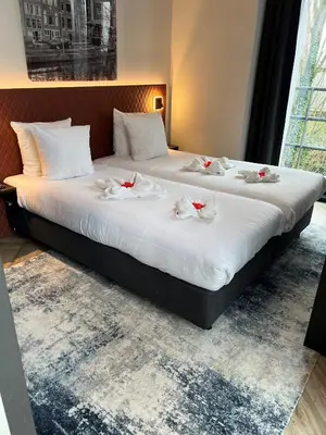 two beds in a hotel room with roses on them at Hotel New Kit in Amsterdam