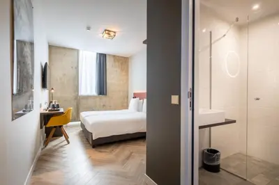 a hotel room with a bed and a bathroom at Hotel New Kit in Amsterdam