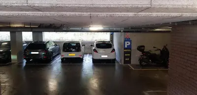 a parking garage with three cars parked in it at Hotel New Kit in Amsterdam