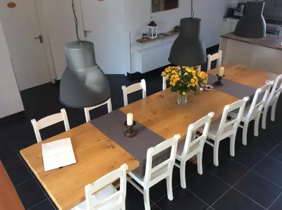 a wooden table and chairs with flowers and candles at de Logerie in Enkhuizen