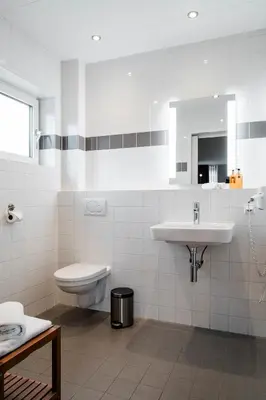 a white bathroom with a sink and a toilet at de Logerie in Enkhuizen