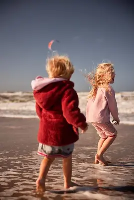 two girls are playing on the beach with a kite at Hotel Bleecker by BHC in Bloemendaal