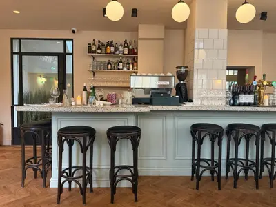 a bar with black stools at a counter at Hotel Bleecker by BHC in Bloemendaal