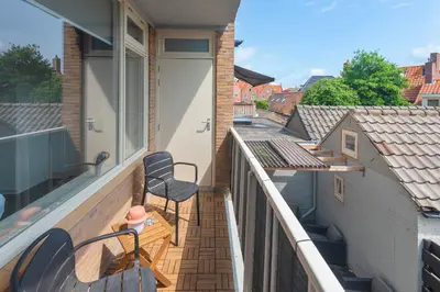 a balcony with chairs and a door on a building at Flamingo Beach Apartments in Zandvoort