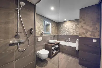 a bathroom with a shower and a toilet and a sink at Inntel Hotels Utrecht Centre in Utrecht