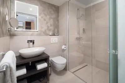 a bathroom with a shower and a toilet and a sink at Inntel Hotels Utrecht Centre in Utrecht