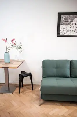 a living room with a green couch and a table at Kuwadro Guesthouse Centrum in Amsterdam