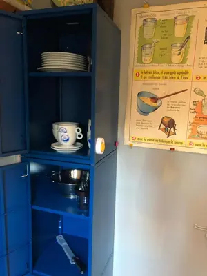 a blue cabinet with plates and dishes in it at Het Pulletje in Westzaan
