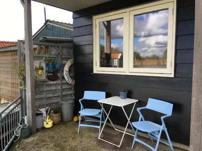 a table and chairs on a patio with a window at Het Pulletje in Westzaan