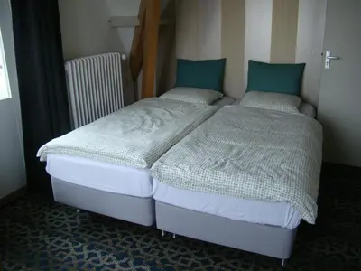 two twin beds in a room with at Pension Sissi in Zandvoort
