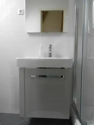 a bathroom with a white sink and a shower at Pension Sissi in Zandvoort