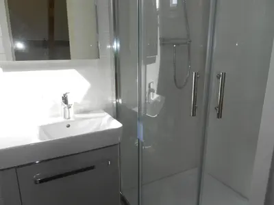 a white bathroom with a shower and a sink at Pension Sissi in Zandvoort