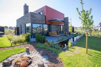 a house with a pond in the yard at Amsterdam Area Residence Oosterwold in Almere