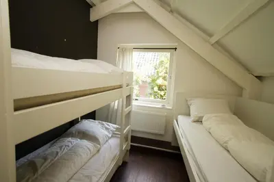 two bunk beds in a room with a window at Hannahhoeve Private House with wifi and free parking for 1 car in Weesp