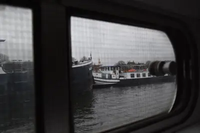 a view of boats in the water through a window at MPS Flora in Amsterdam