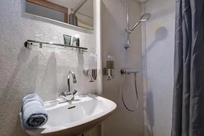a white bathroom with a sink and a shower at MPS Flora in Amsterdam
