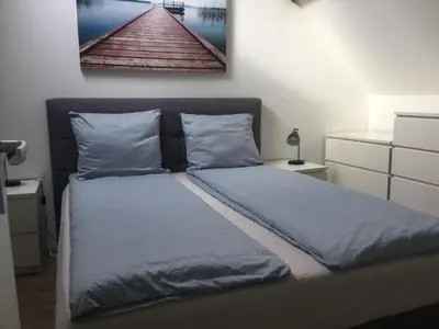 a bed with blue sheets and a picture on the wall at Appartementen Purmerend A in Purmerend