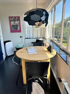 a room with a wooden table with chairs and a lamp at SWEETS - Gerben Wagenaarbrug in Amsterdam