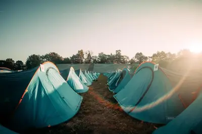 a group of tents lined up in a field at The ESN Kingsday Campsite in Amsterdam