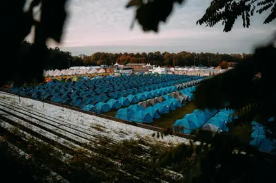 a row of blue chairs in a field at The ESN Kingsday Campsite in Amsterdam