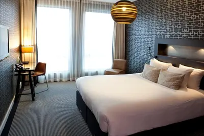 a hotel room with a large bed and a desk at Skotel Amsterdam, Hotelschool The Hague in Amsterdam