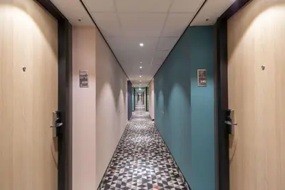 a long corridor with blue walls and a tile floor at Hampton By Hilton Utrecht Centraal Station in Utrecht