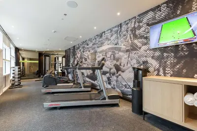 a gym with cardio machines and a flat screen tv at Hampton By Hilton Utrecht Centraal Station in Utrecht