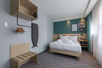 a bedroom with a bed and a bench in it at Hampton By Hilton Utrecht Centraal Station in Utrecht