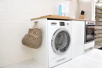 a white washing machine in a kitchen with a purse at Beachhouse Bosweg in Noordwijk aan Zee