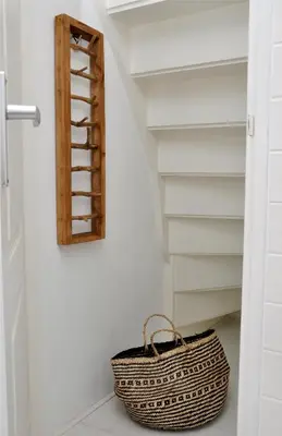 a basket sits on the floor in a bathroom with a shelf at Beachhouse Bosweg in Noordwijk aan Zee