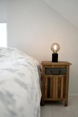 a lamp on a night stand next to a bed at Beachhouse Bosweg in Noordwijk aan Zee