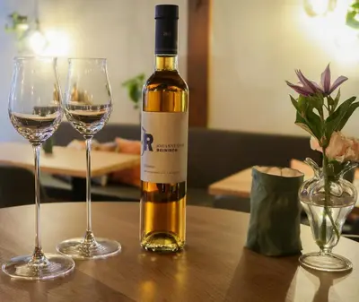 a bottle of wine sitting on a table with two glasses at Hotel 't Fnidsen in Alkmaar